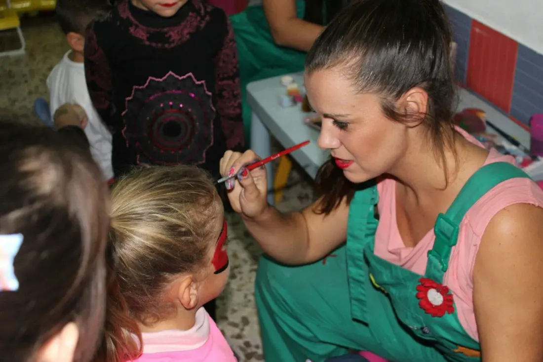 Pintacaras a una niña en una fiesta de cumpleaños